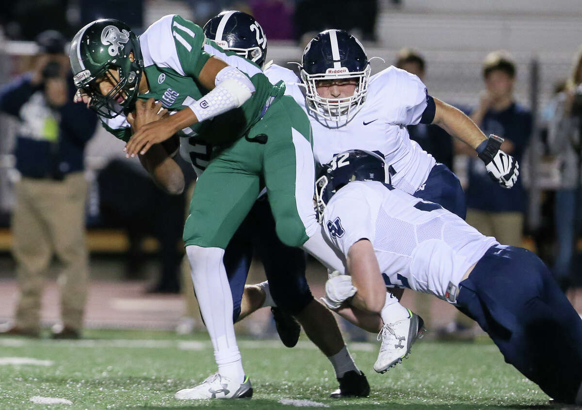 Reagan quarterback Kellen Mond (left) is brough down by Smithson Valley's AJ Singleton (from right), Jacob Staffier and Marquis Duncan during the first half of their Class 6A Division I bi-district game at Comalander Stadium on Friday, Nov. 13, 2015. MARVIN PFEIFFER/ mpfeiffer@express-news.net