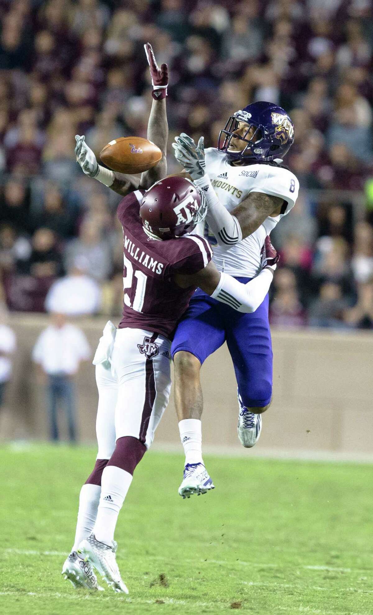 Western Carolina's Spearman Robinson (8) leaps over Texas A&M’s Brandon Williams (21) to make the catch during the first half of an NCAA college football game Saturday, Nov. 14, 2015, in College Station, Texas. (AP Photo/Juan DeLeon)