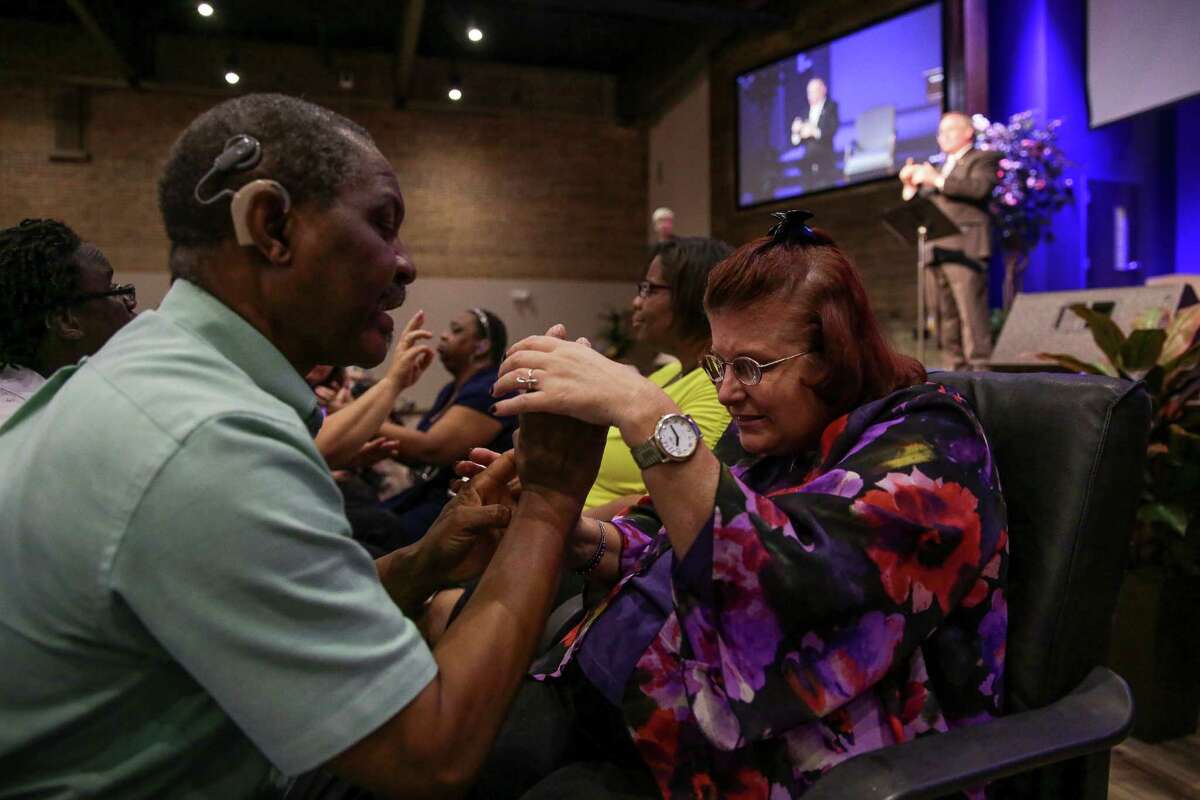 LeAnn Cayer﻿ holds onto the hands of tactile signer Kunle Adegboye as he translates the sermon to ﻿her Sunday at Woodhaven Baptist Deaf Church.﻿