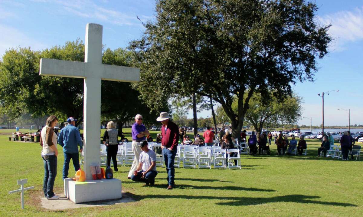 A group gathers around at Port Neches' Riverfront Park before a vigil to honor a cross the Freedom From Religion Foundation is trying to remove.