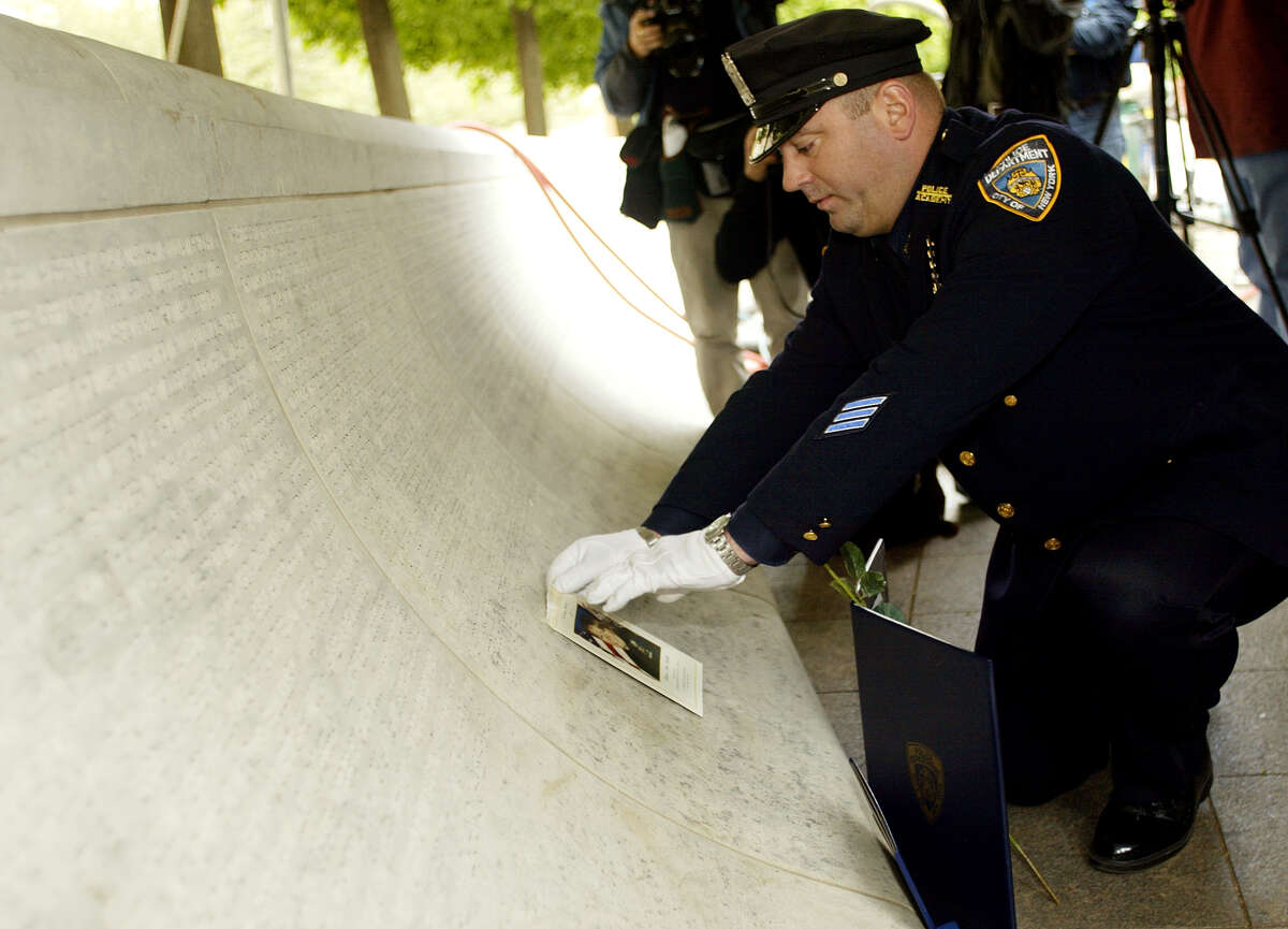 New York Police Department police officer James Smith places a photo of his late wife, NYPD police officer Moira Smith, on the National Law Enforcement Officers Memorial in Washington, DC, 29 April 2002.