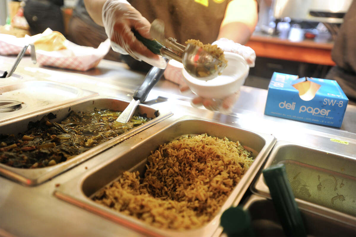 Greens and dirty rice being served up at Frenchy's Chicken.