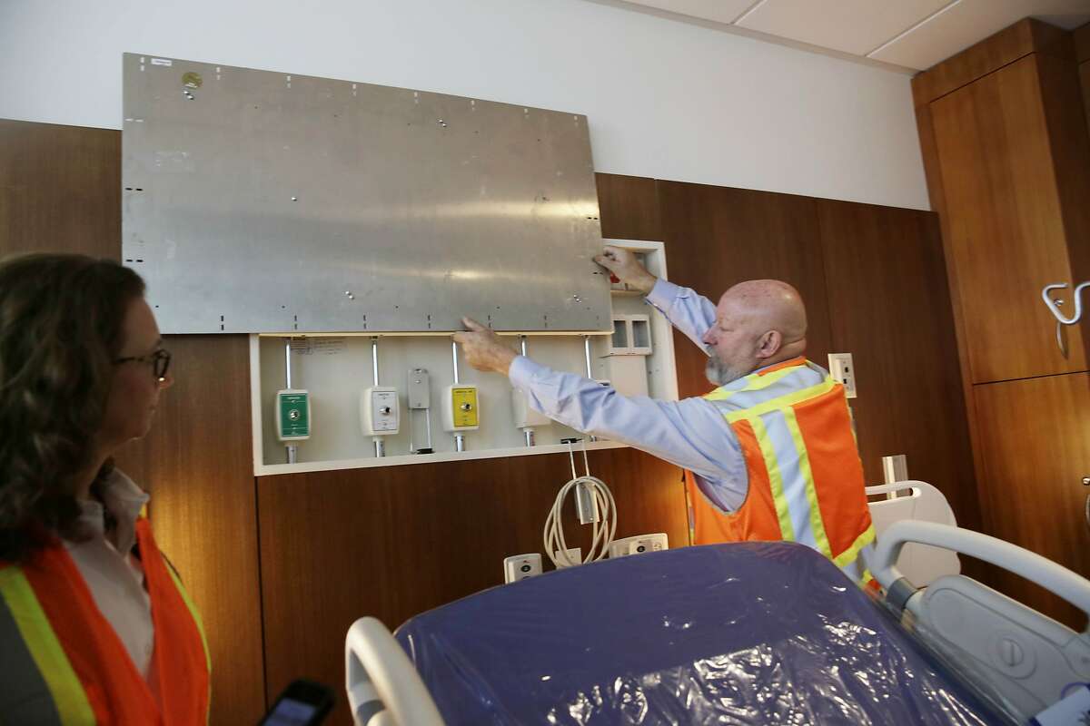 Terry Saltz (right), rebuild program director Zuckerberg San Francisco General , shows people on a tour equipment hidden behind a panel in the Pediatric Care and Family Brith center as Maya Vasquez (left), nurse manager, birth center, Zuckerberg San Francisco General, watches during a tour at the Priscilla Chan and Mark Zuckerberg San Francisco General Hospital and Trauma Center on Tuesday, November 17, 2015 in San Francisco, Calif.