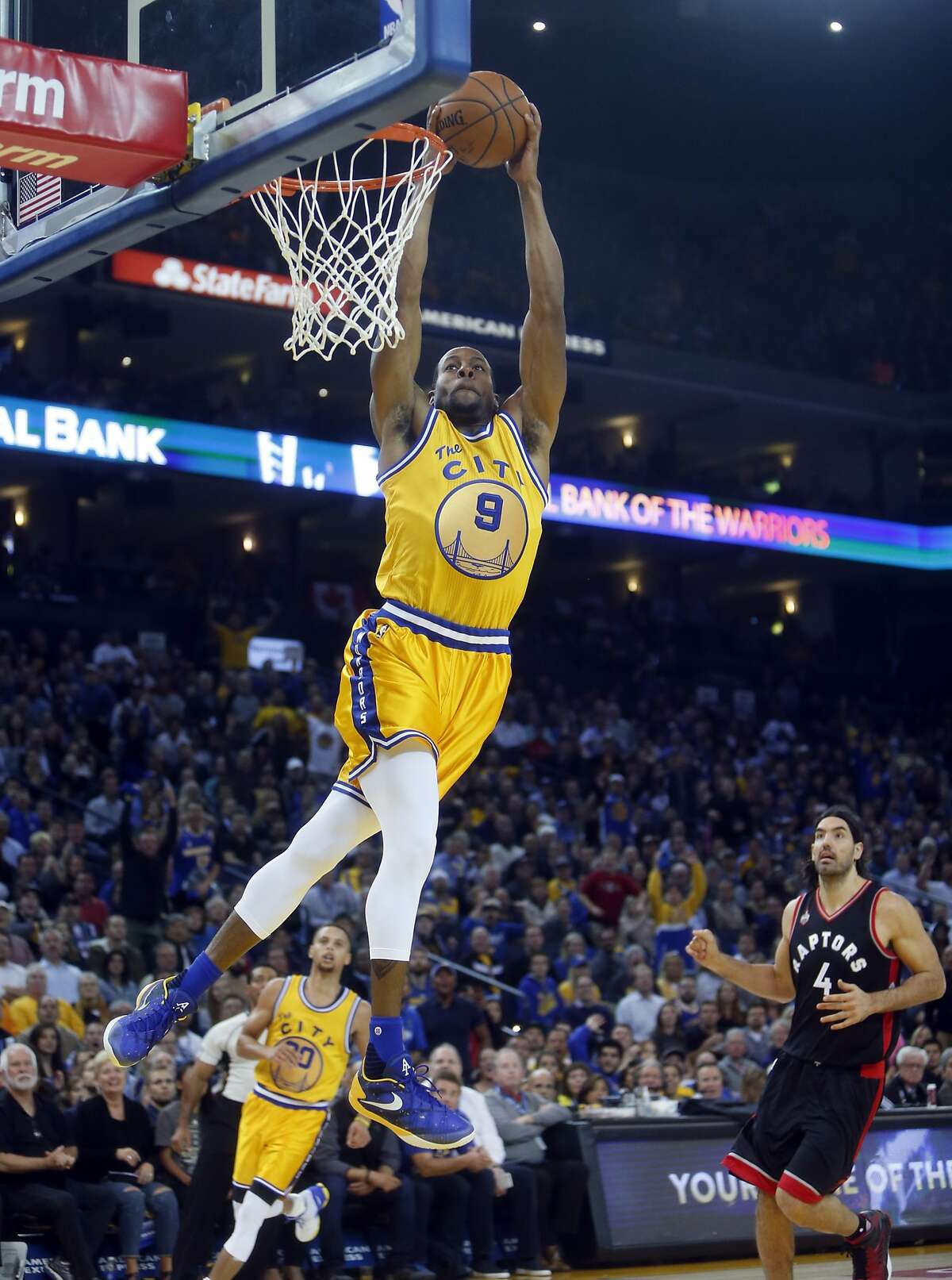 Golden State Warriors' Andre Iguodala dunks as Toronto Raptors' Luis Scola watches in 2nd quarter during NBA game at Oracle Arena in Oakland, Calif., on Tuesday, November 17, 2015.