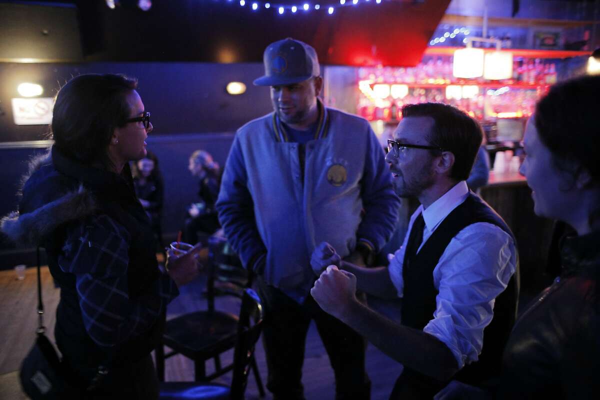 l-R, Sophia Brose and her fiance Carl Fox chat with Jefferson Bergey, after they listened to The Lucky Devils play a showcase for people who are considering hiring them for their weddings at the Neck of the Woods in San Francisco, Calif., on Tuesday, November 17, 2015.