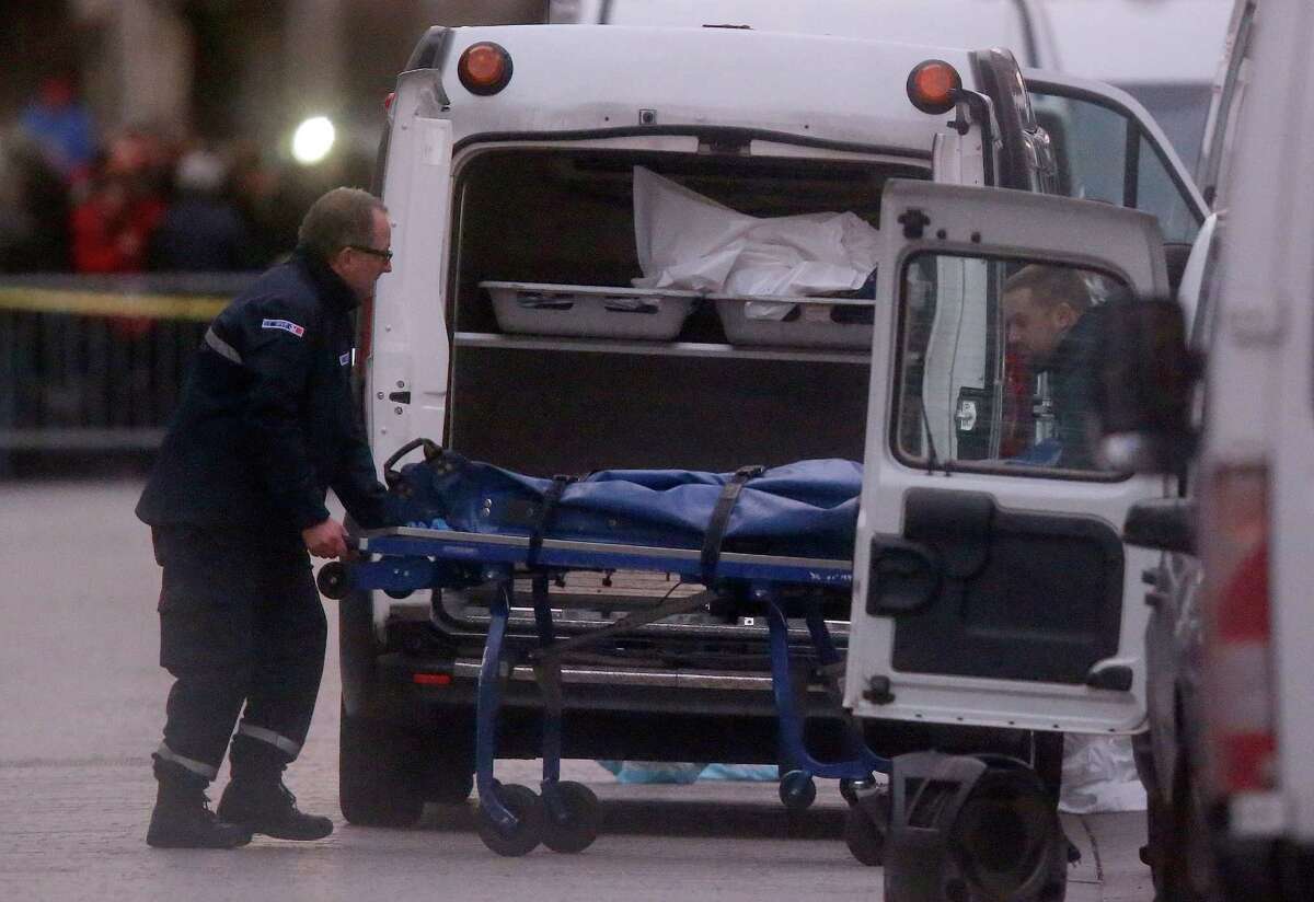Two men carry a stretcher with a body into a hearse after an intervention of security forces against a group of extremists in Saint-Denis, near Paris, Wednesday, Nov. 18, 2015. A woman wearing an explosive suicide vest blew herself up Wednesday as heavily armed police tried to storm a suburban Paris apartment where the suspected mastermind of last week's attacks was believed to be holed up, police said. (AP Photo/Michel Euler) ORG XMIT: FAS162