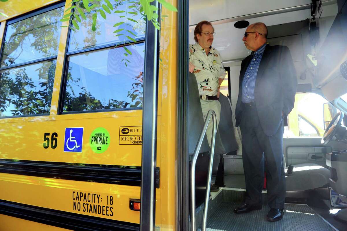 Board of Education member Mark Holden and Superintendent of Schools Freeman Burr take a look at Shelton's new fleet of propane-powered school buses Thursday, Aug. 15, 2013 at the city's bus depot.