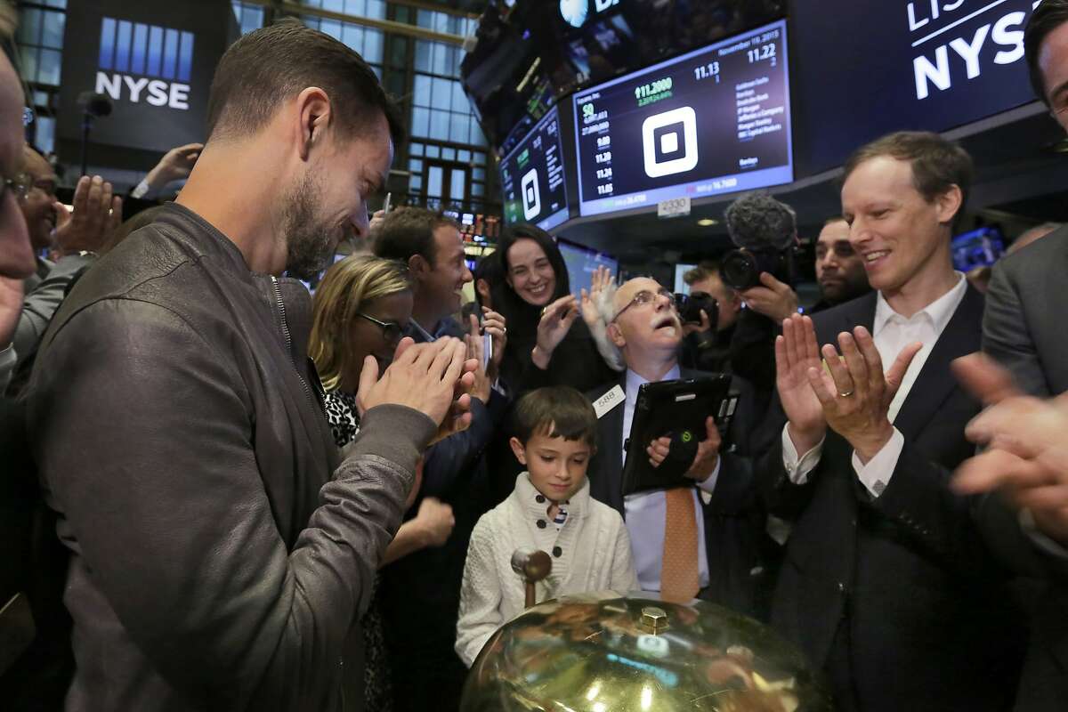 Mac Riley, center, son of Square CFO Sarah Friar, rings a ceremonial bell as the Square IPO begins trading, on the floor of the New York Stock Exchange, Thursday, Nov. 19, 2015. Flanking Riley are Square CEO Jack Dorsey, left, and co-founder Jim McKelvey, far right. Square, the 6-year-old startup known for its white, cube-shaped card readers that plug into smartphones, is surging in its first day as a publicly traded company. (AP Photo/Richard Drew)