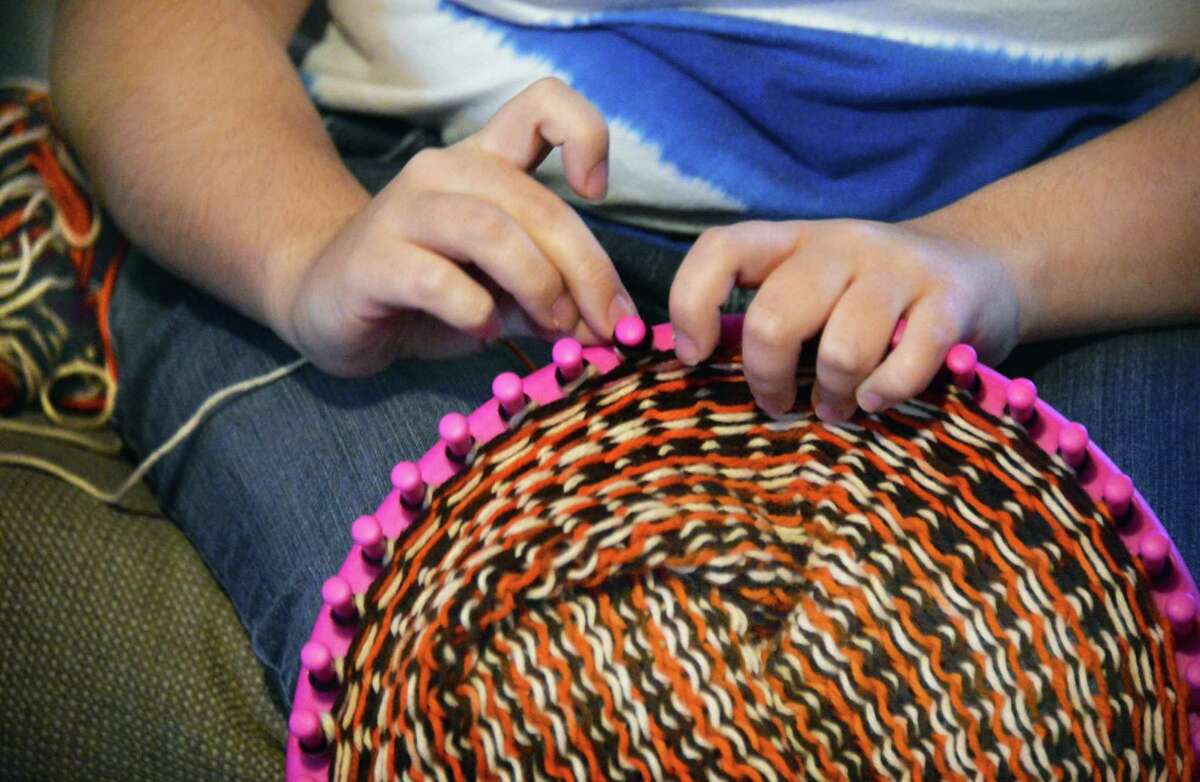 Shelter clients knit hats for homeless