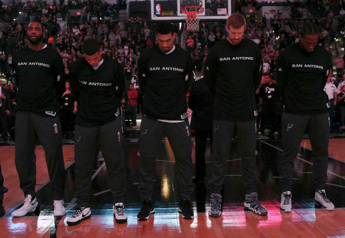 San Antonio Spurs' Danny Green, center, bows his head during the National Anthem before their game against the Denver Nuggets at the AT&T Center, Wednesday, Nov. 18, 2015.