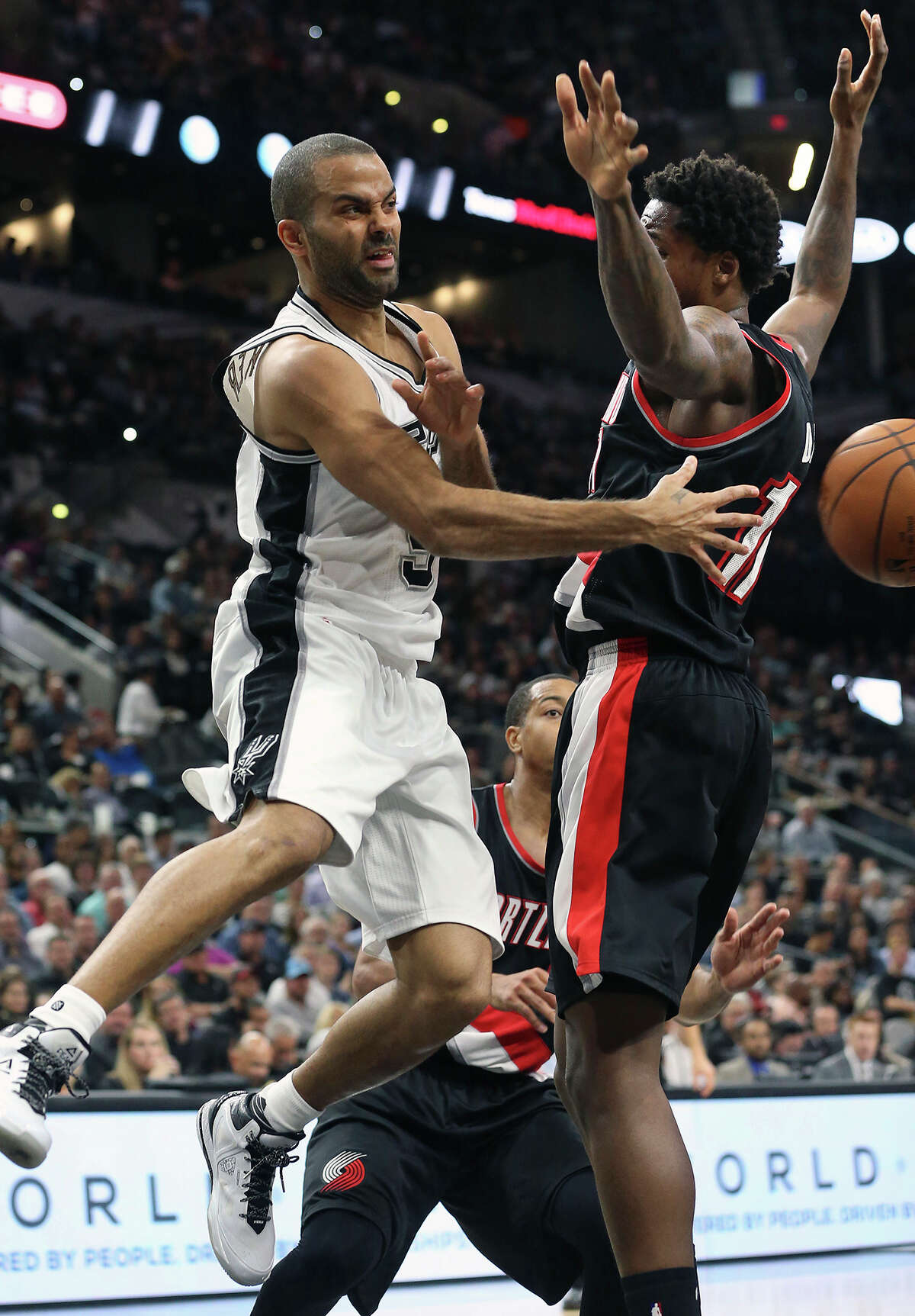 Tony Parker passes around Ed Davis as the Spurs host Portland at the AT&T Center on November 16, 2015.