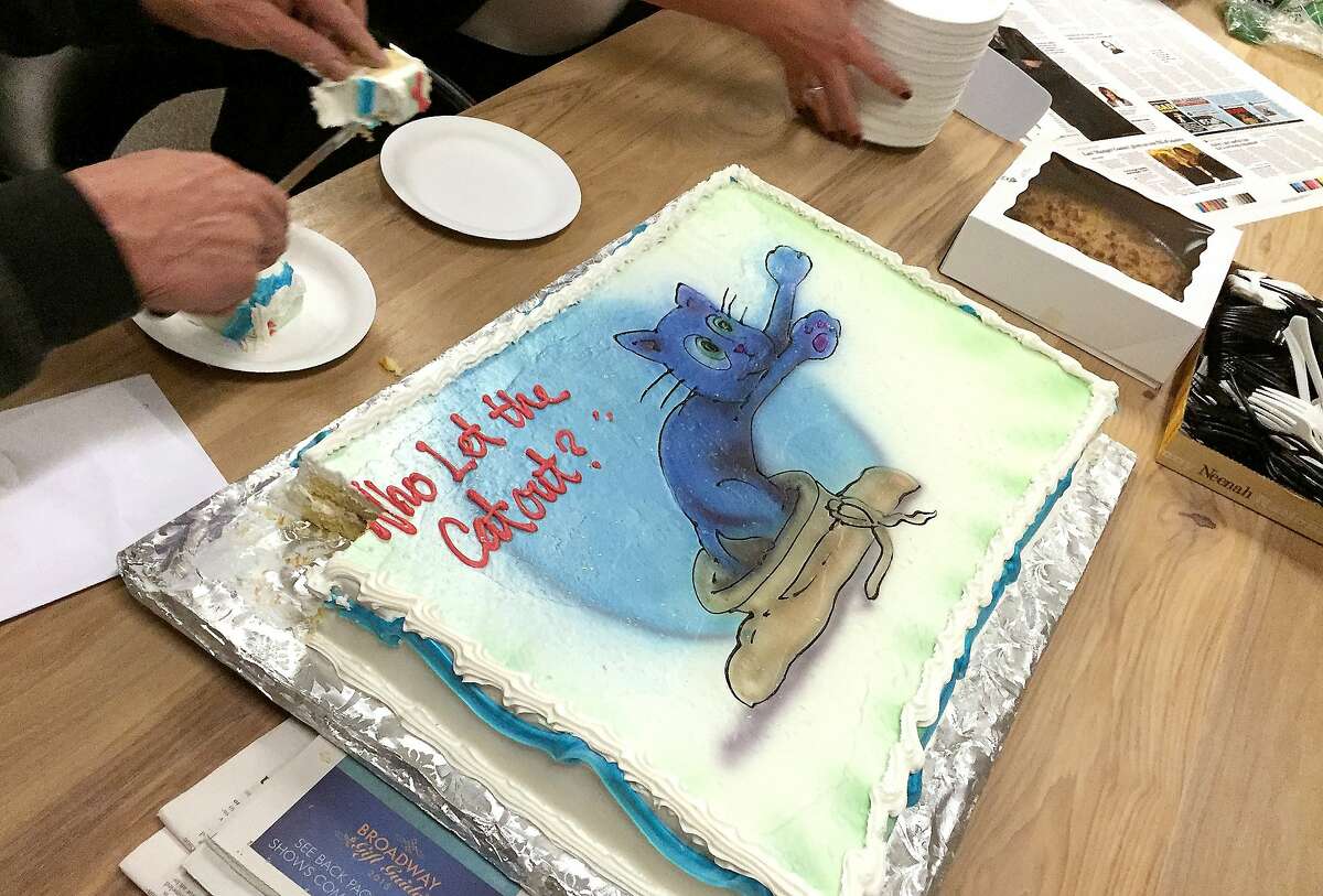 A cake is presented to Columnist Jon Carroll Thursday, November 19, 2015 who retired from the San Francisco Chronicle after 33 years working at the newspaper.
