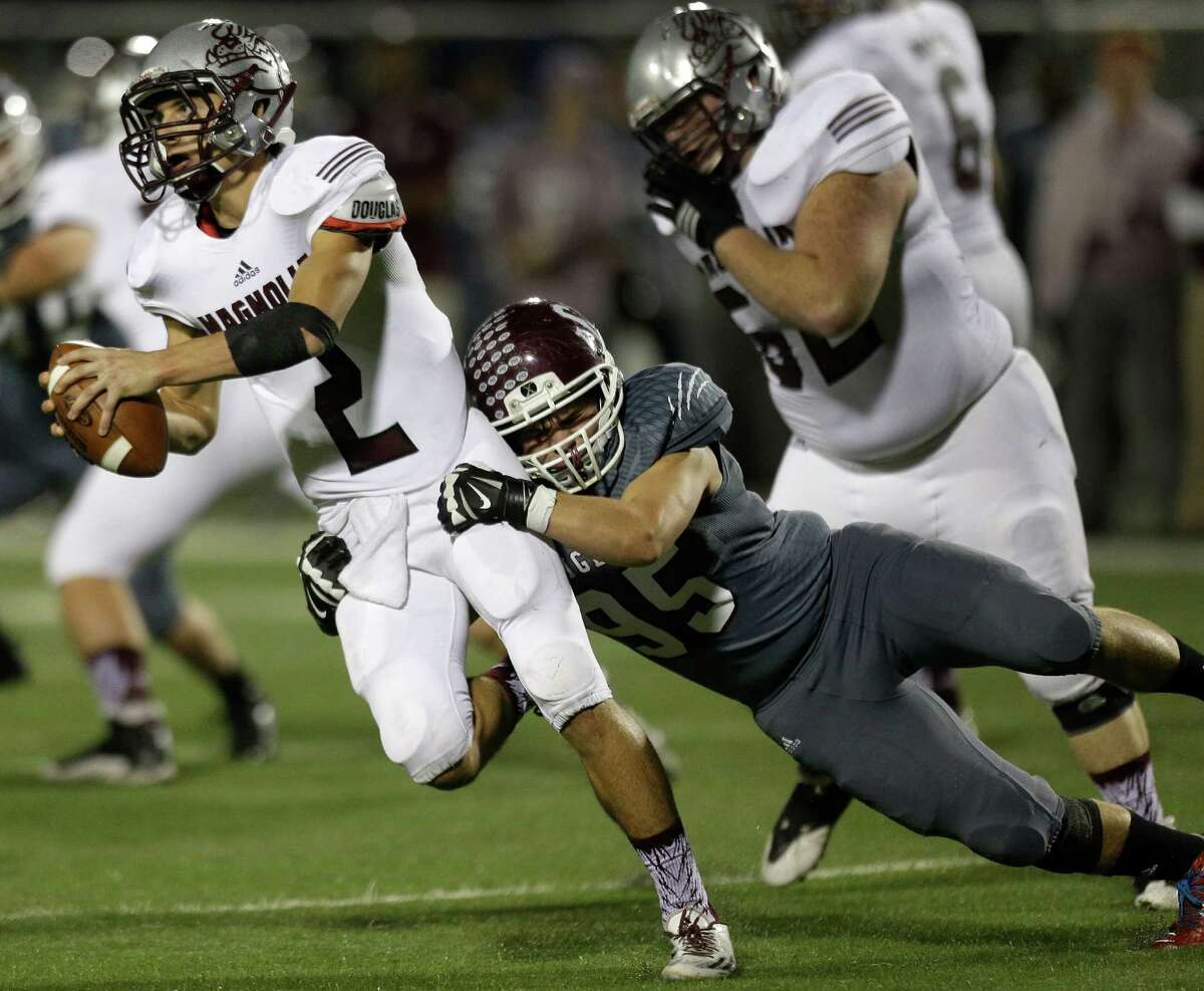 Magnolia quarterback Reese Mason (2) is sacked by A&M Consolidated defensive lineman Noah Langley (95) during the first quarter of a Class 5A Division II Area playoff football game at Waller ISD Stadium on Thursday, Nov. 19, 2015, in Waller.