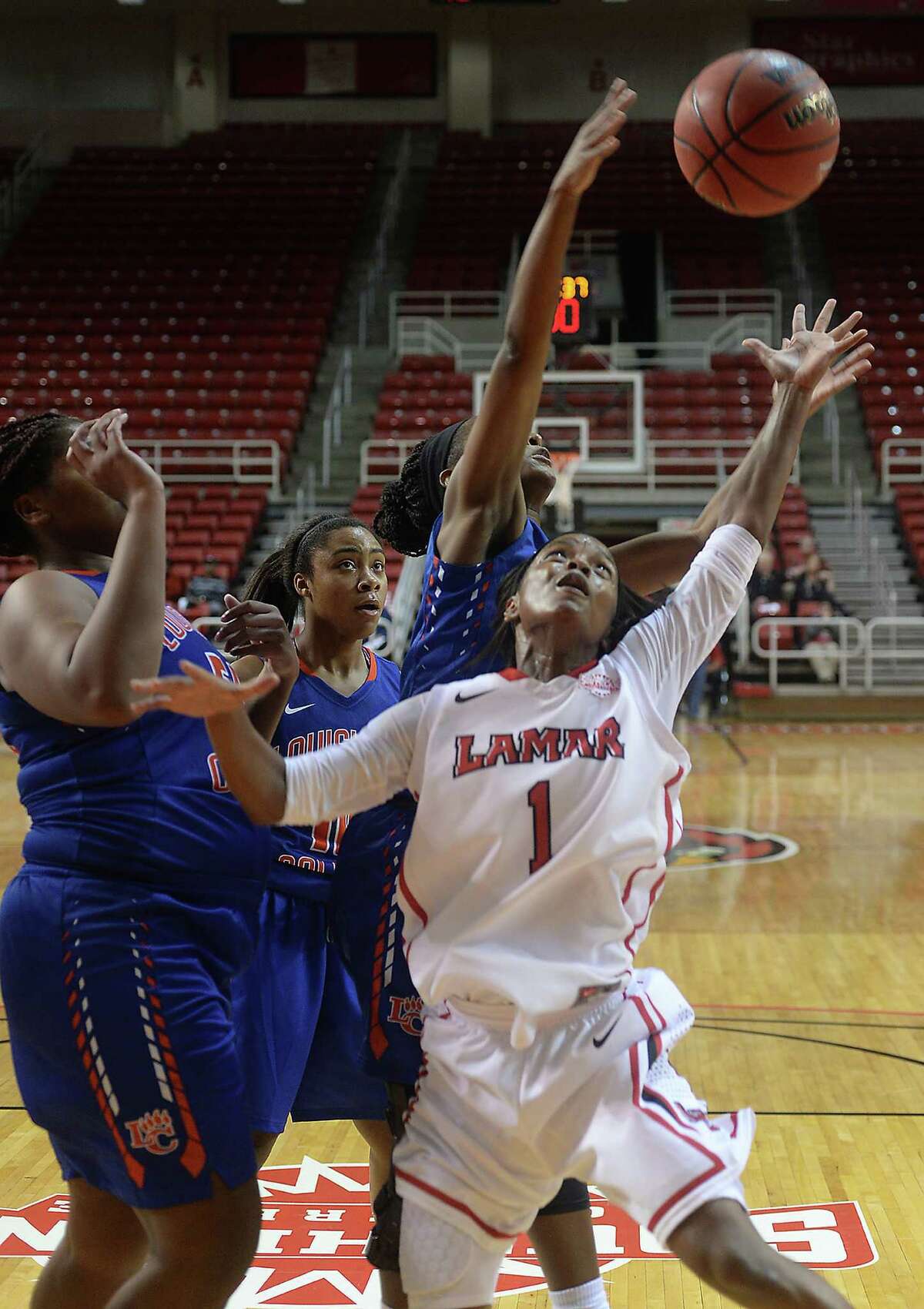Lamar University's Addesha Collins is in the mix with Louisiana College for the rebound during the Lady Cardinals' home opener Thursday night at the Montagne Center. Photo taken Thursday, November 19, 2015 Kim Brent/The Enterprise