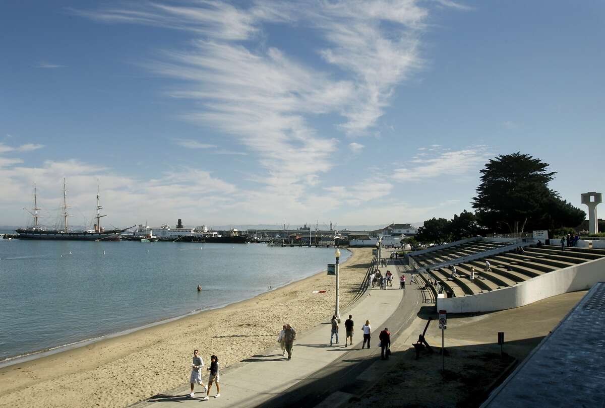 Aquatic Park visitors walk along the promenade in front of the Maritime Museum in San Francisco, Calif.
