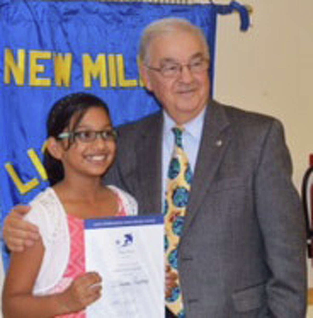 Schaghticoke Middle School interim principal Len Tomasello recognizes Ishaani Pradeep, a sixth-grade student at the New Milford school, for her poster submission as part of the 28th annual Lions International Peace Poster Contest at a recent New Milford Lions meeting.