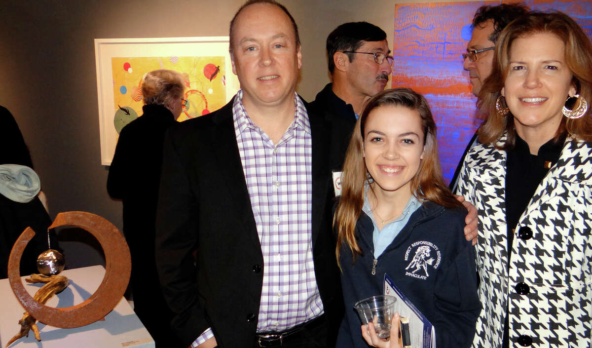 Chris Plaisted with his sculpture, "Who's Dreaming Who," accompanied by daughter Savannah and wife Catherine at the "Dreamscapes" exhibit opening at the Westport Arts Center.