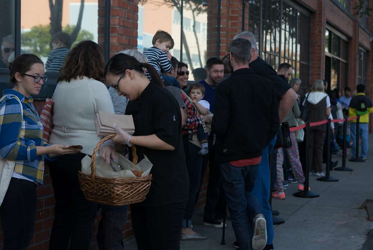 Yier Moua hands out doughnut holes at the line forming at the SFMade holiday gift fair held at the Pintrest building on Saturday, Nov. 21, 2015 in San Francisco, Calif.