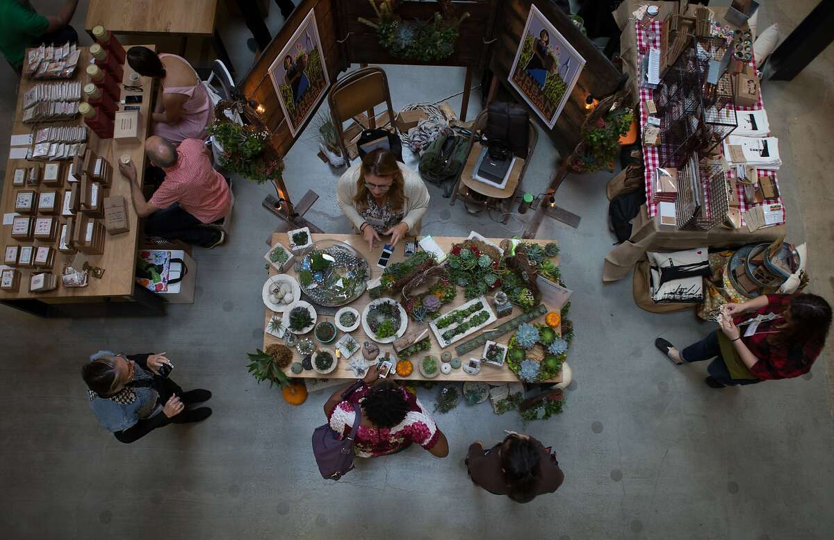 Gift shoppers look at the wares sold by local businesses at the SFMade holiday gift fair held at the Pintrest building on Saturday, Nov. 21, 2015 in San Francisco, Calif.