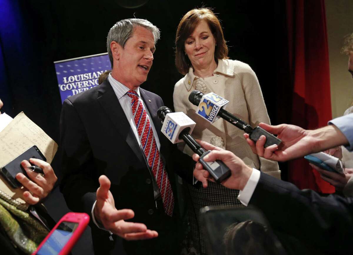 FILE - In this Monday, Nov. 16, 2015, file photo, Louisiana gubernatorial candidate Sen. David Vitter, R-La., left, speaks to reporters after his debate against Democratic candidate John Bel Edwards, in Baton Rouge, La.Vitter's wife Wendy, right, looks on. Louisiana voters are deciding on Saturday, Nov. 21 whether to elect a Democrat to statewide office for the first time since 2008. (AP Photo/Gerald Herbert)