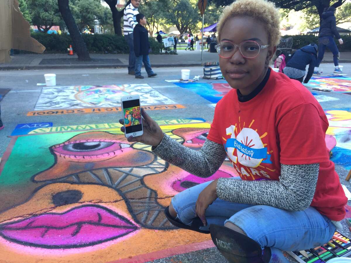 Soon after 16-year-old Leah Green's Summer Creek High School art teacher nominated her to draw in the festival, she spent days planning a design, pictured on her phone. But upon arrival, she opted to hone in on the top right corner of her plan, what she called a "dismembered face."