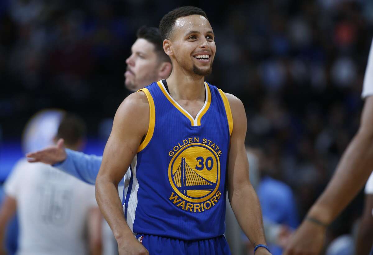 Golden State Warriors guard Stephen Curry jokes with teammates after hitting a 3-point shot against the Denver Nuggets during the first half of an NBA basketball game Sunday, Nov. 22, 2015, in Denver. (AP Photo/David Zalubowski)