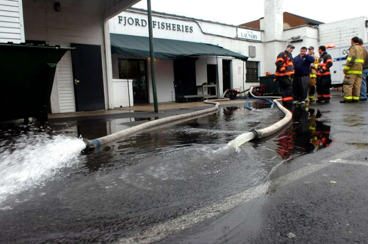 Cos Cob Fire Police pump out the cellar of the Greenwich Laundry. The sewer backed up causing the flood, on Tuesday, March 30, 2010.