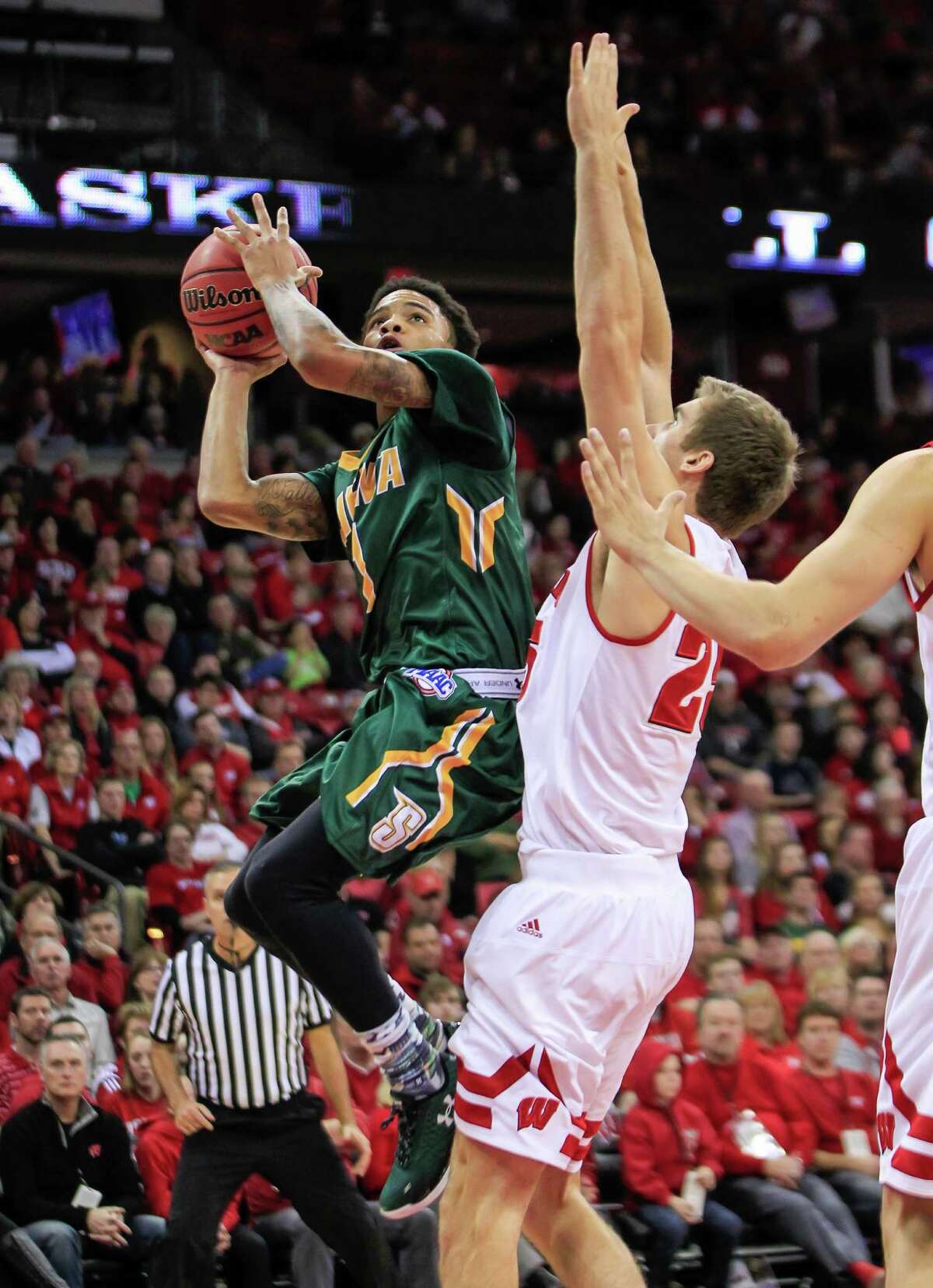 Siena's Marquis Wright, left, shoots against Wisconsin's Ethan Happ (22) during the first half of an NCAA college basketball game Sunday, Nov. 15, 2015, in Madison, Wis. (AP Photo/Andy Manis) ORG XMIT: WIAM107