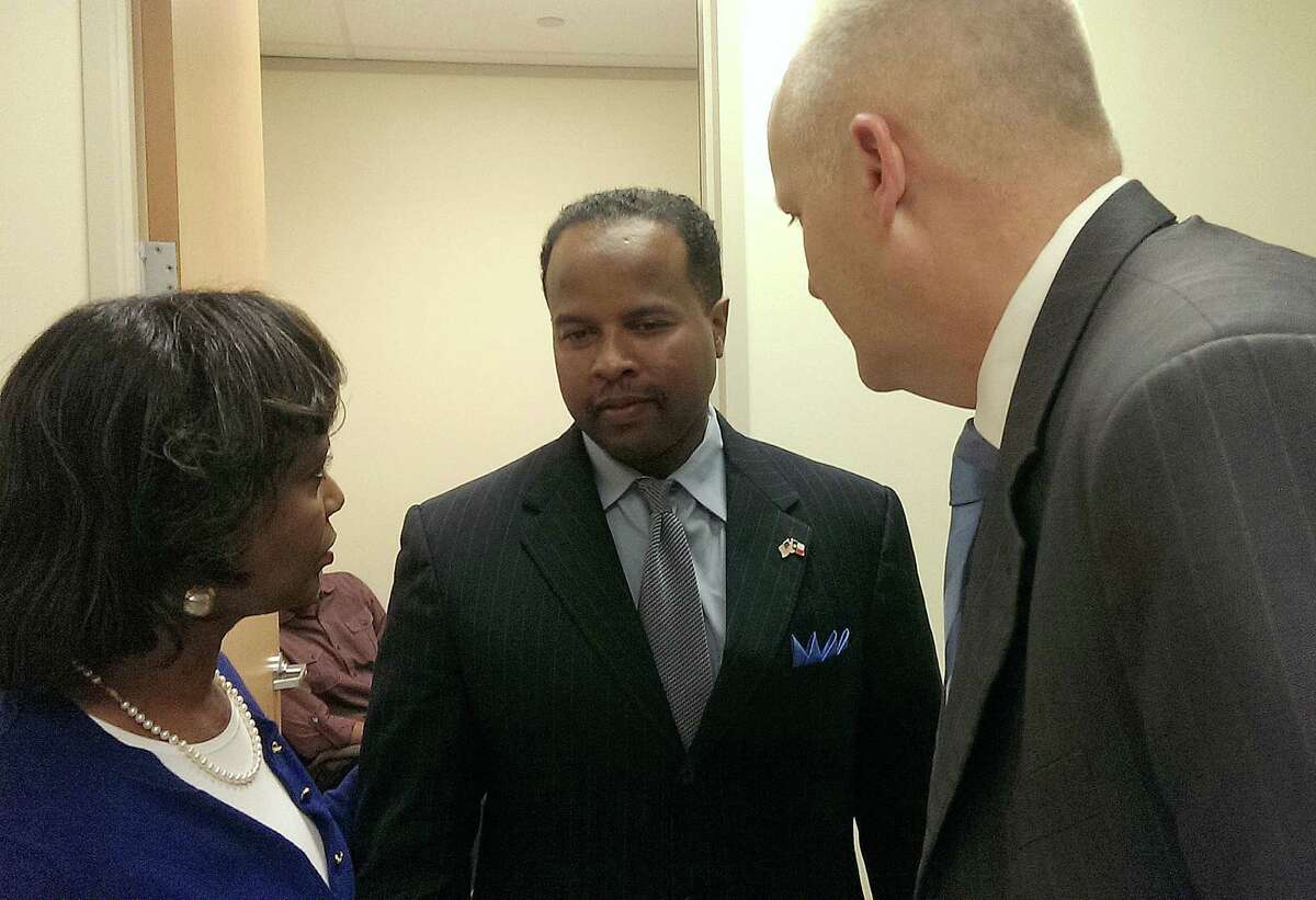 State Rep. Ron Reynolds talks with his attorneys Vivian King and Stephen Jackson in 2014.
