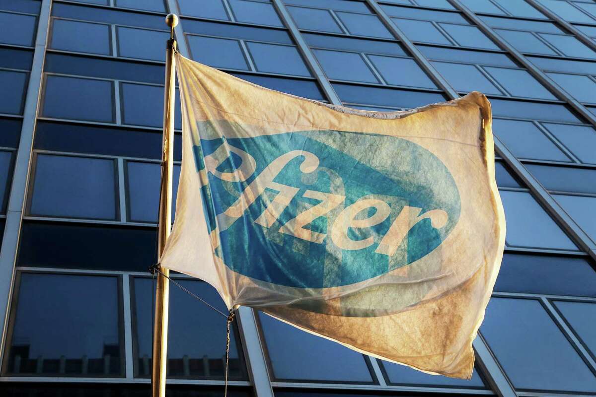 A Pfizer flag is displayed in front of its headquarters in New York. In an inversion, Pfizer could lower its corporate tax load by reorganizing as a company in Ireland, which has a lower tax rate.﻿