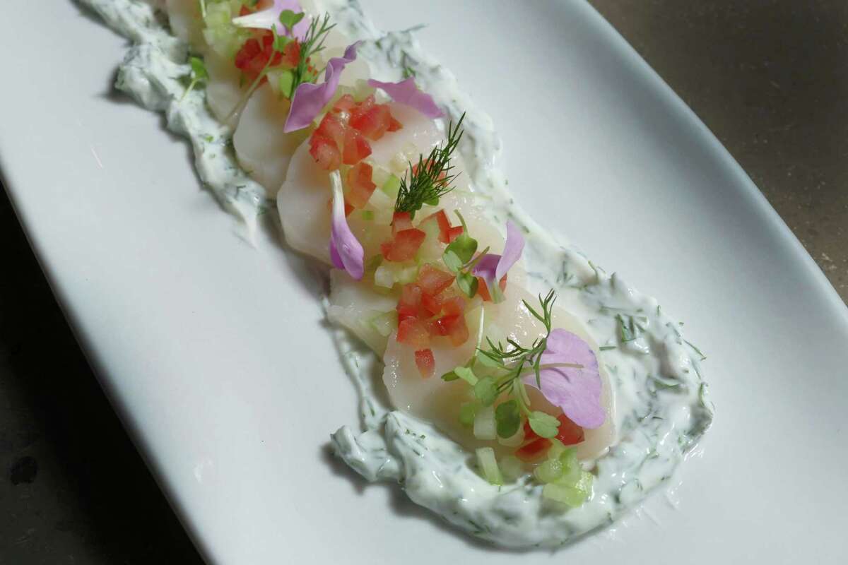 This plating of scallop sashimi features cucumbers, heirloom tomatoes and housemade labneh.