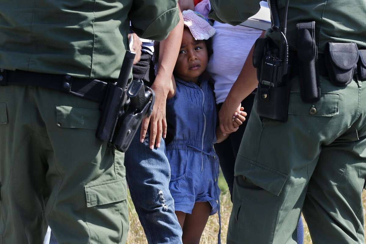 A young girl with U.S. Border Patrol agents near Anzalduas Park, southwest of McAllen, in 2014.