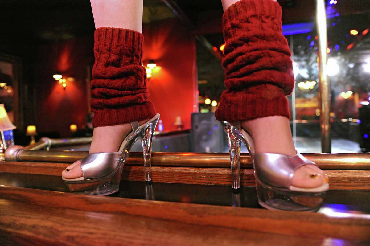 A dancer stands on the perimeter of a strip club stage.  (Lori Van Buren / Times Union)