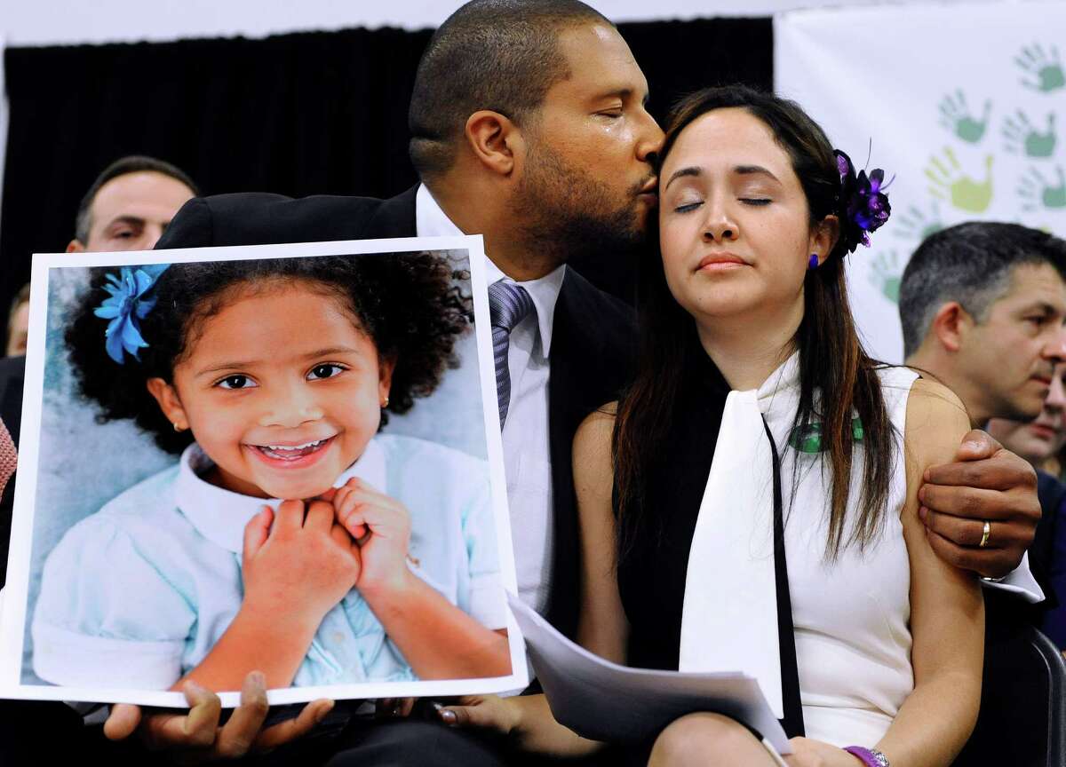 FILE - In this Jan. 14, 2013 file photo, Jimmy Greene, left, kisses his wife Nelba Marquez-Greene as he holds a portrait of their daughter, Sandy Hook School shooting victim Ana Marquez-Greene, at a news conference in Newtown, Conn. Jimmy Greene, an internationally acclaimed jazz saxophonist, composer and bandleader, is preparing an album, called ?“A Beautiful Life,?” inspired by his daughter. He plans to play selections from the album Sunday, Aug. 10, 2014 at the Litchfield, Conn., Jazz Festival. (AP Photo/Jessica Hill, File)