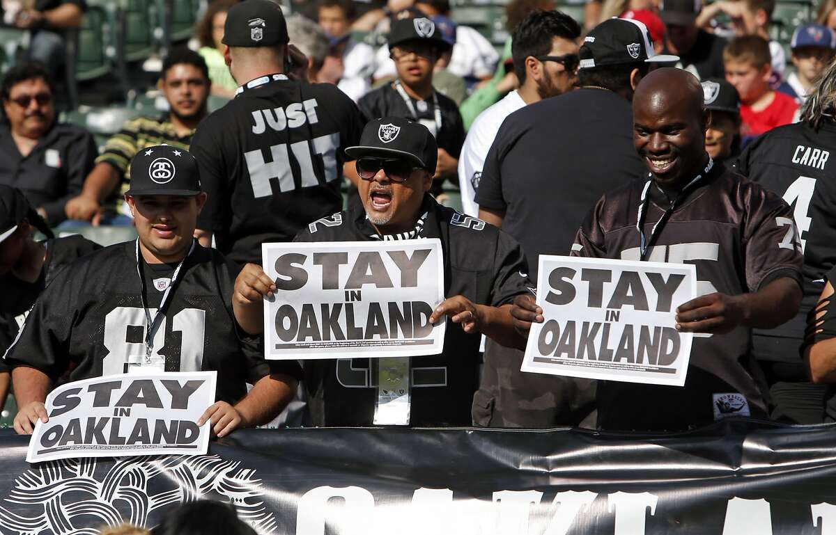 Oakland Raiders' fans show "Stay in Oakland" signs before Raiders play Arizona Cardinals in preseason game at O.co Coliseum in Oakland, Calif., on Sunday, Aug. 30, 2015.