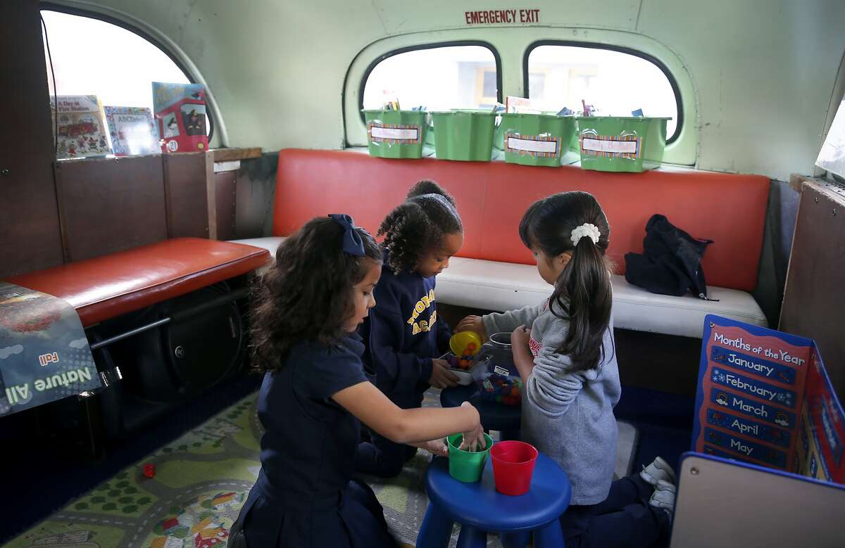 Valentina Morales (left), Mariah Andrews (center) and Yaretzi Prado play during a preschool operating out of an old bus at the Aspire Monarch Academy school in Oakland, Calif. on Wednesday, Nov. 18, 2015.