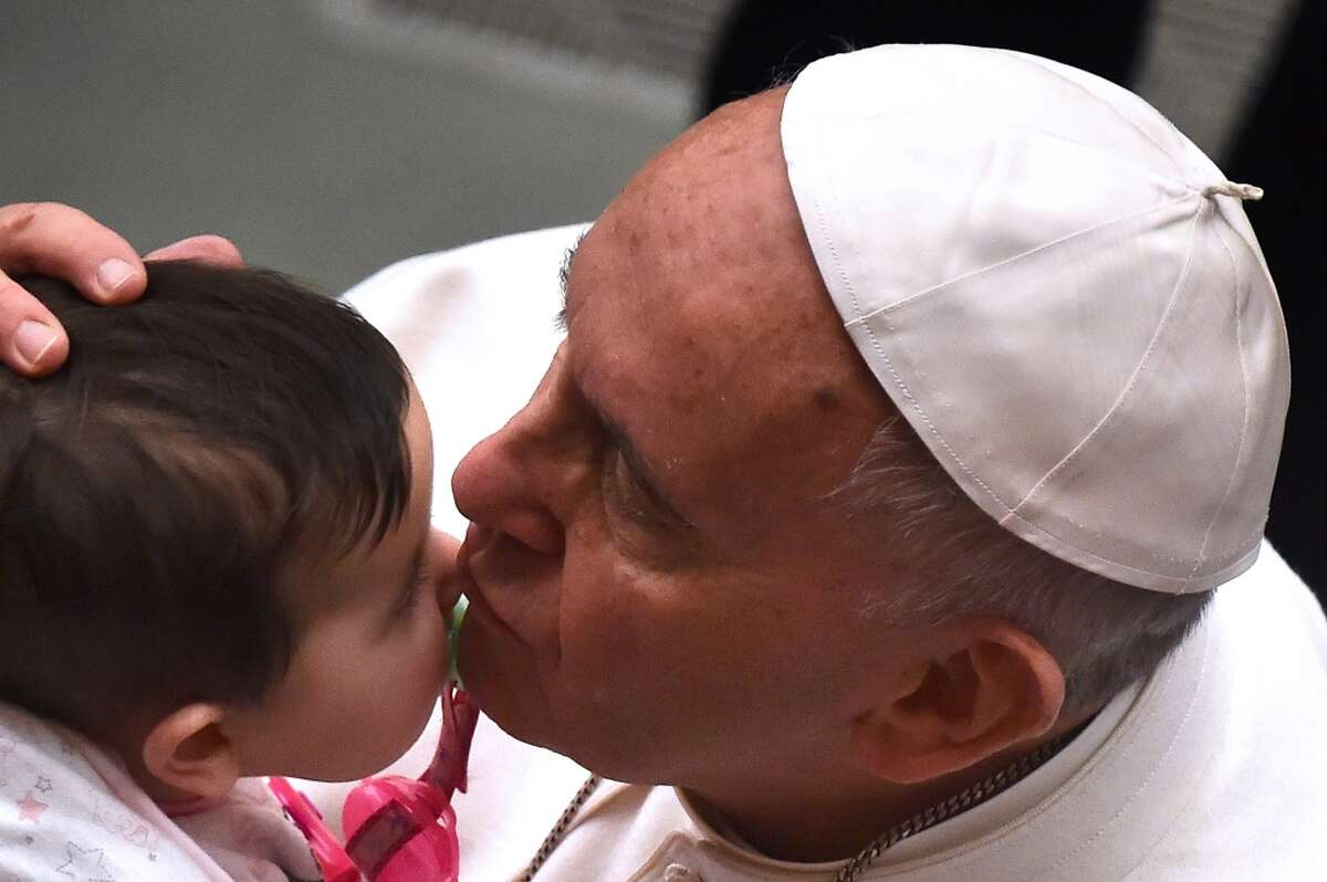 Pope Francis kisses a baby during a special audience for the Cassano allo Jonio diocese at the Vatican on February 21, 2015.