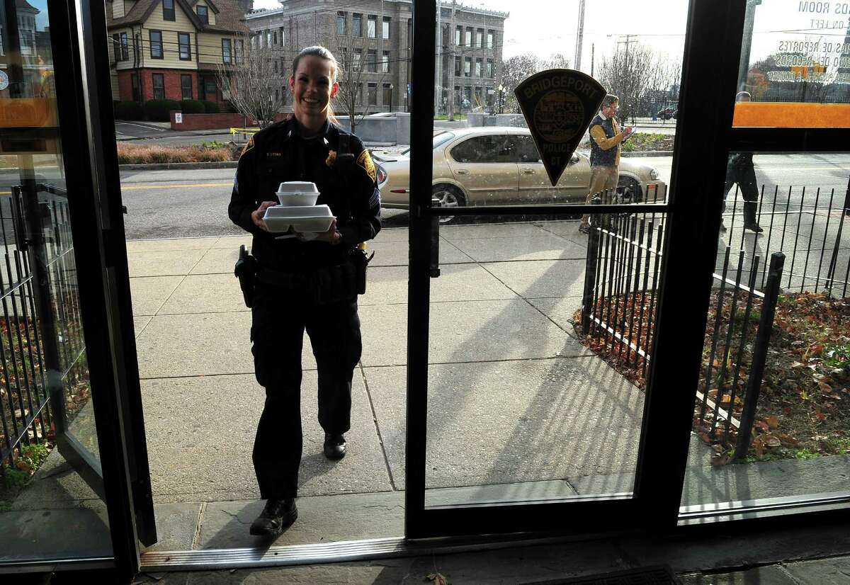 FILE - Sgt. Stacey Lyons takes her Thanksgiving Day dinner inside police headquarters on Congress Street in Bridgepor on Thursday Nov. 26, 2015.
