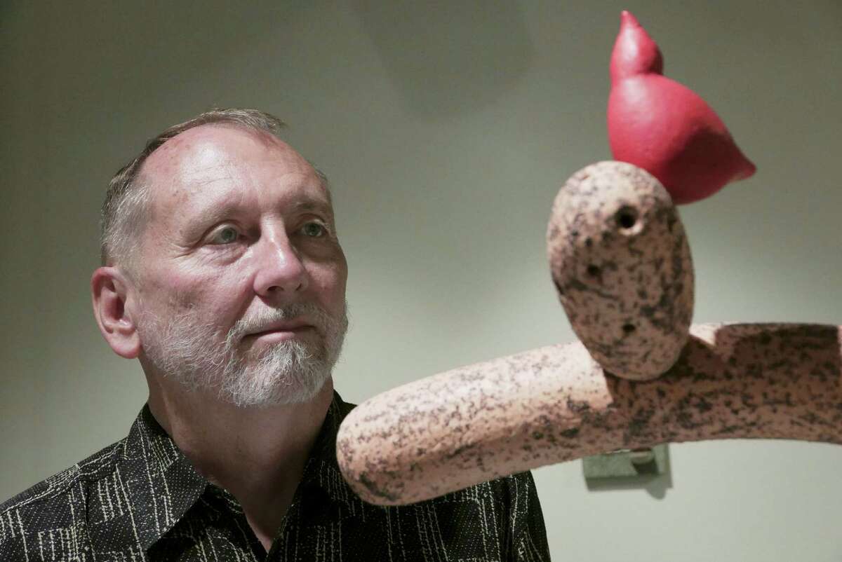 Artist Dennis Smith contemplates his “Landscape with Red Bird #1,” which  is among his ceramics being shown at Southwest School of Art.