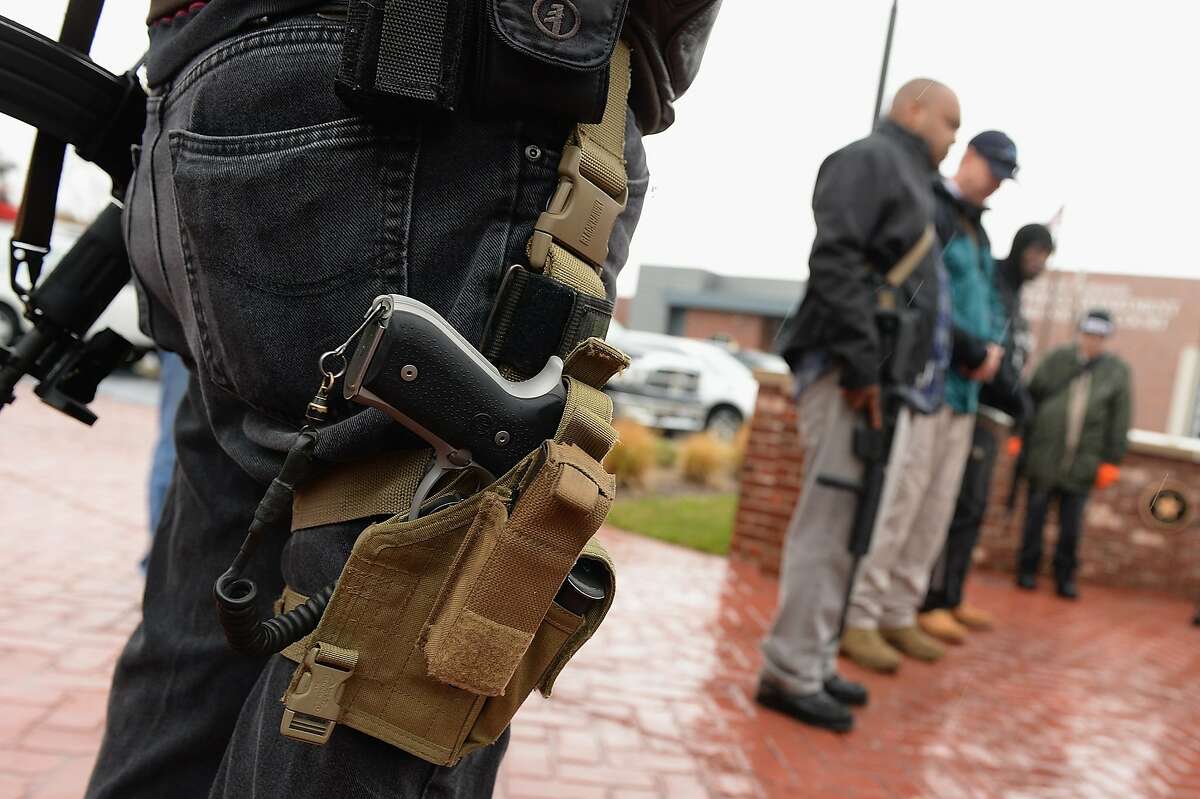 Open carry gun activists participate in a march in front of the city police department and minicipal court on November 16, 2015 in Ferguson, Missouri. About a dozen supporters of gun rights gathered in Ferguson November 16 for what organizers hoped would be a racially integrated open-carry march to demonstrate that Second Amendment rights are for everybody. AFP PHOTO / MICHAEL B. THOMASMichael B. Thomas/AFP/Getty Images