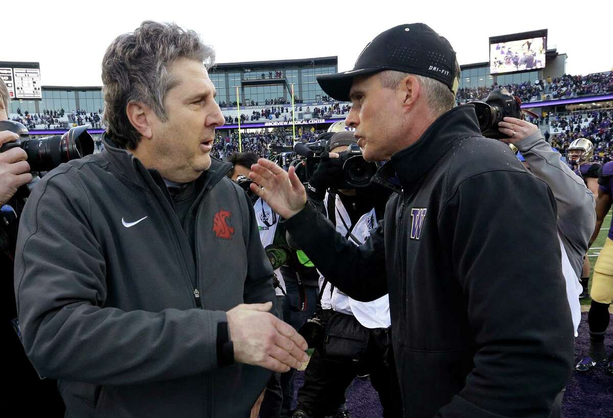 Washington State coach Mike Leach, left, is greeted by Washington coach Chris Petersen after an NCAA college football game Friday, Nov. 27, 2015, in Seattle. Washington won the annual Apple Cup, 45-10. (AP Photo/Elaine Thompson)