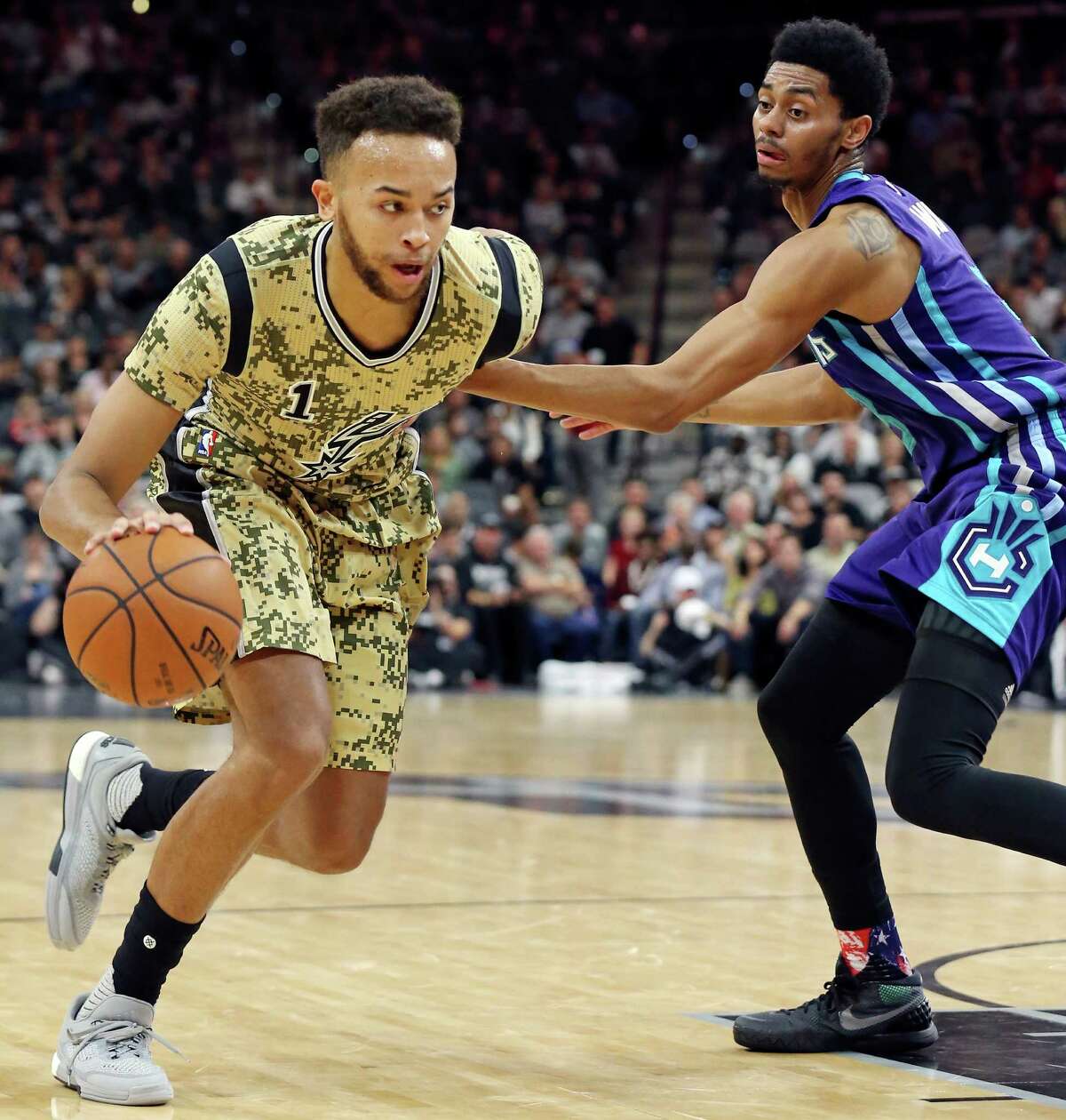 Spurs’ Kyle Anderson looks for room around the Charlotte Hornets’ Jeremy Lamb during second half action on Nov. 7, 2015 at the AT&T Center.