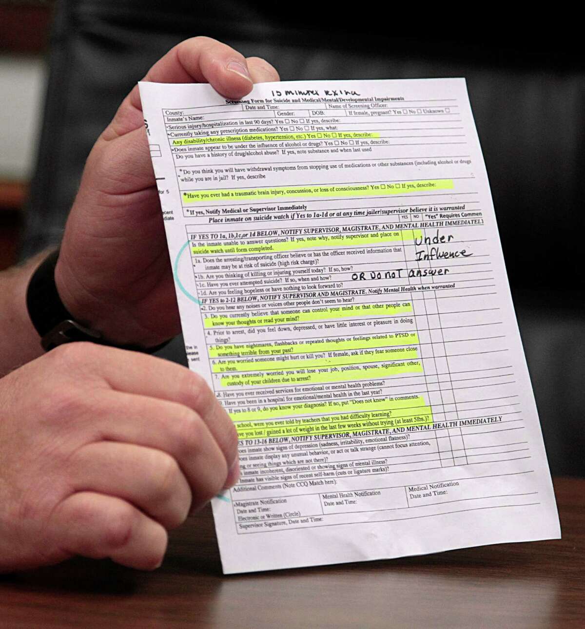 Fort Bend County Sheriff Troy Nehls holds a Screening Form for Suicide and Medical and Mental Impairments during an interview on recent suicides in the county's jail in Richmond.