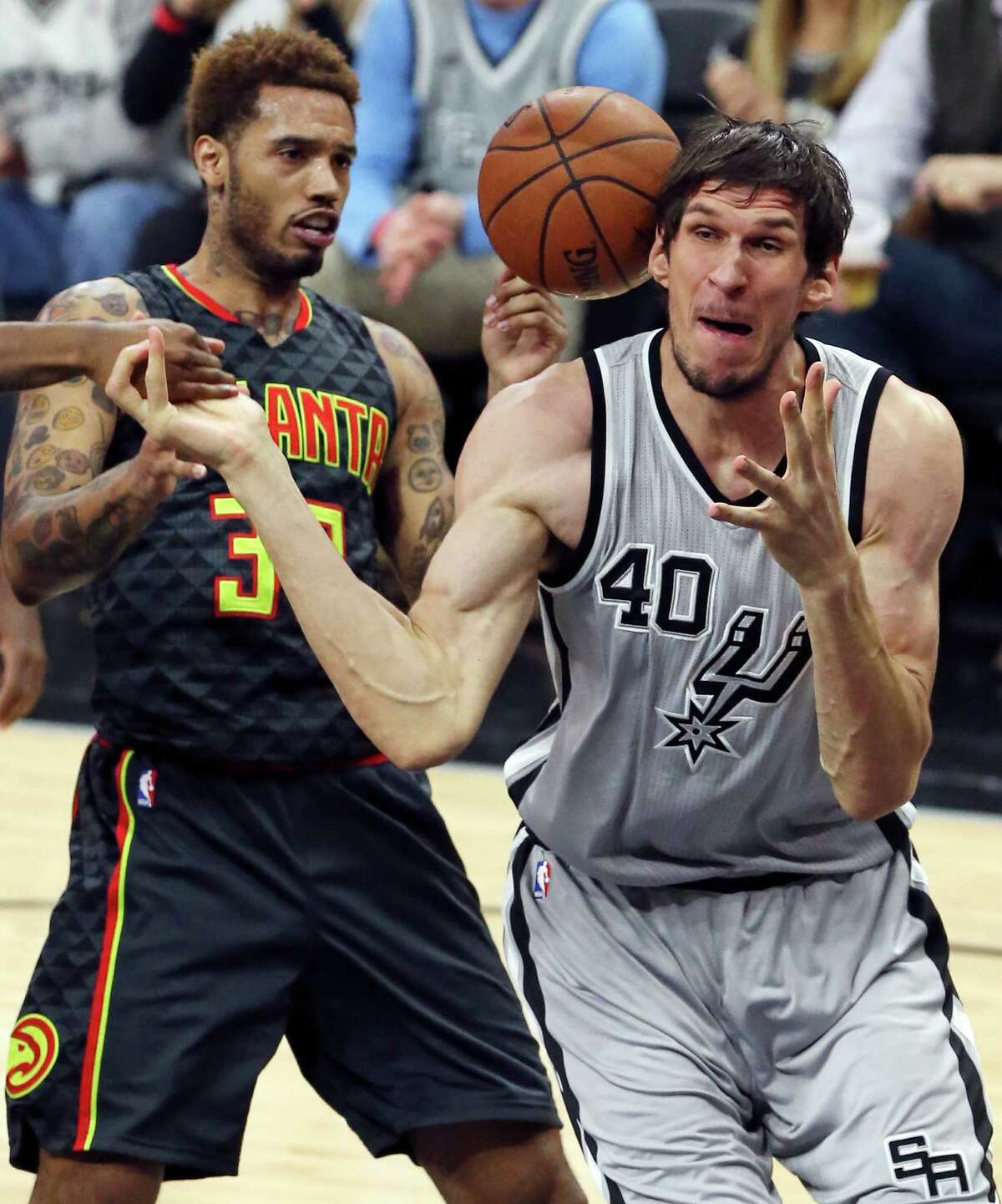 Atlanta Hawks' Mike Scott and San Antonio Spurs' Boban Marjanovic grab for a loose ball during second half action Saturday Nov. 28, 2015 at the AT&T Center. The Spurs won 108-88.