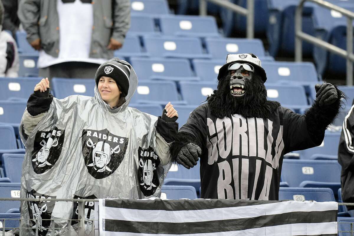 Oakland Raiders fans watch players warm up.