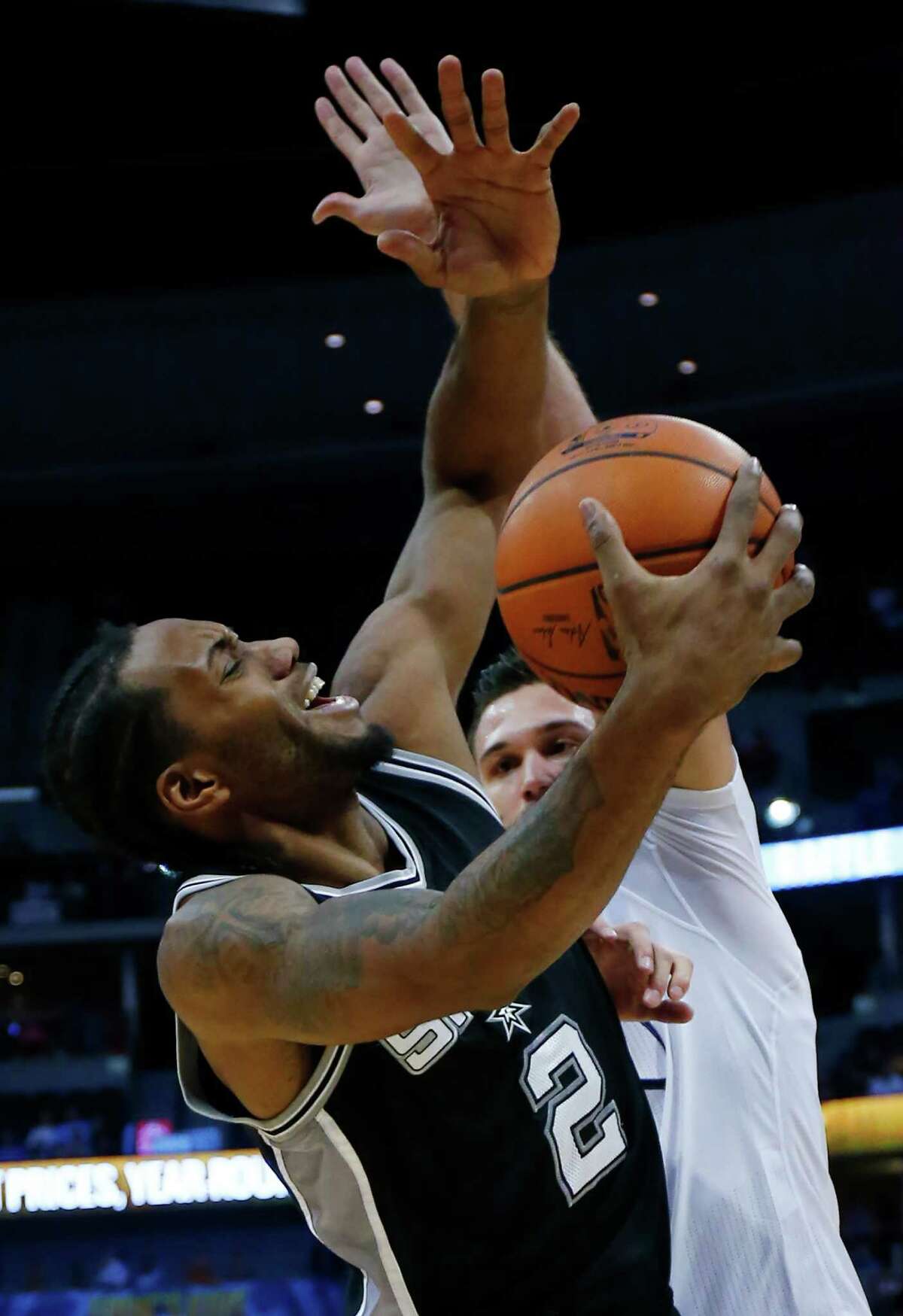 San Antonio Spurs forward Kawhi Leonard (2) goes up to shoot against Denver Nuggets forward Danilo Gallinari, from Italy, applies pressure during the fourth quarter of an NBA basketball game Friday, Nov. 27, 2015, in Denver. (AP Photo/Jack Dempsey)
