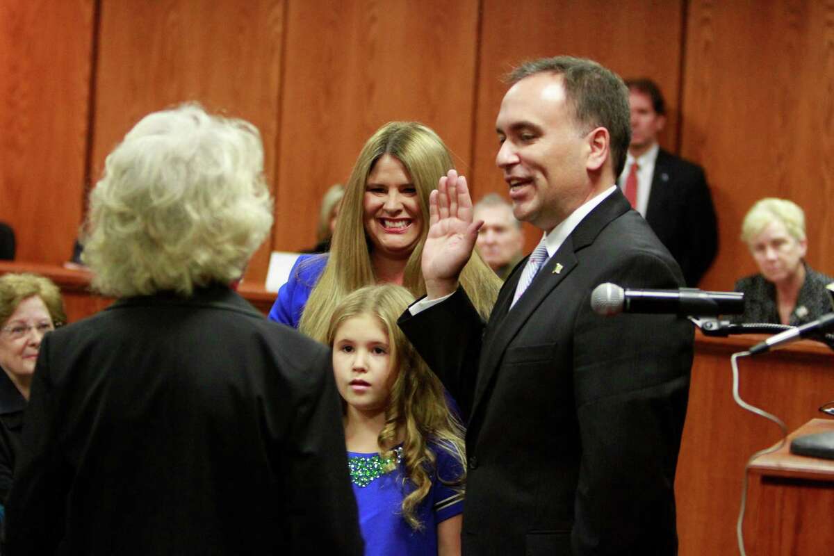 First Selectman Peter J. Tesei stands with his family as Rebecca S. Breed administers the oath of office during a swearing-in ceremony at the Greenwich Town Hall on Sunday.