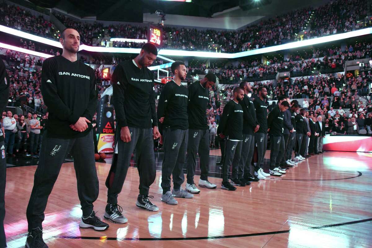 Manu Ginobili, left, Tim Duncan, Kyle Anderson and other members of the San Antonio Spurs pay respects during playing of the Star-Spangled Banner before the team's game against the Dallas Mavericks in NBA action at the AT&T Center on Wednesday, Nov. 25, 2015.