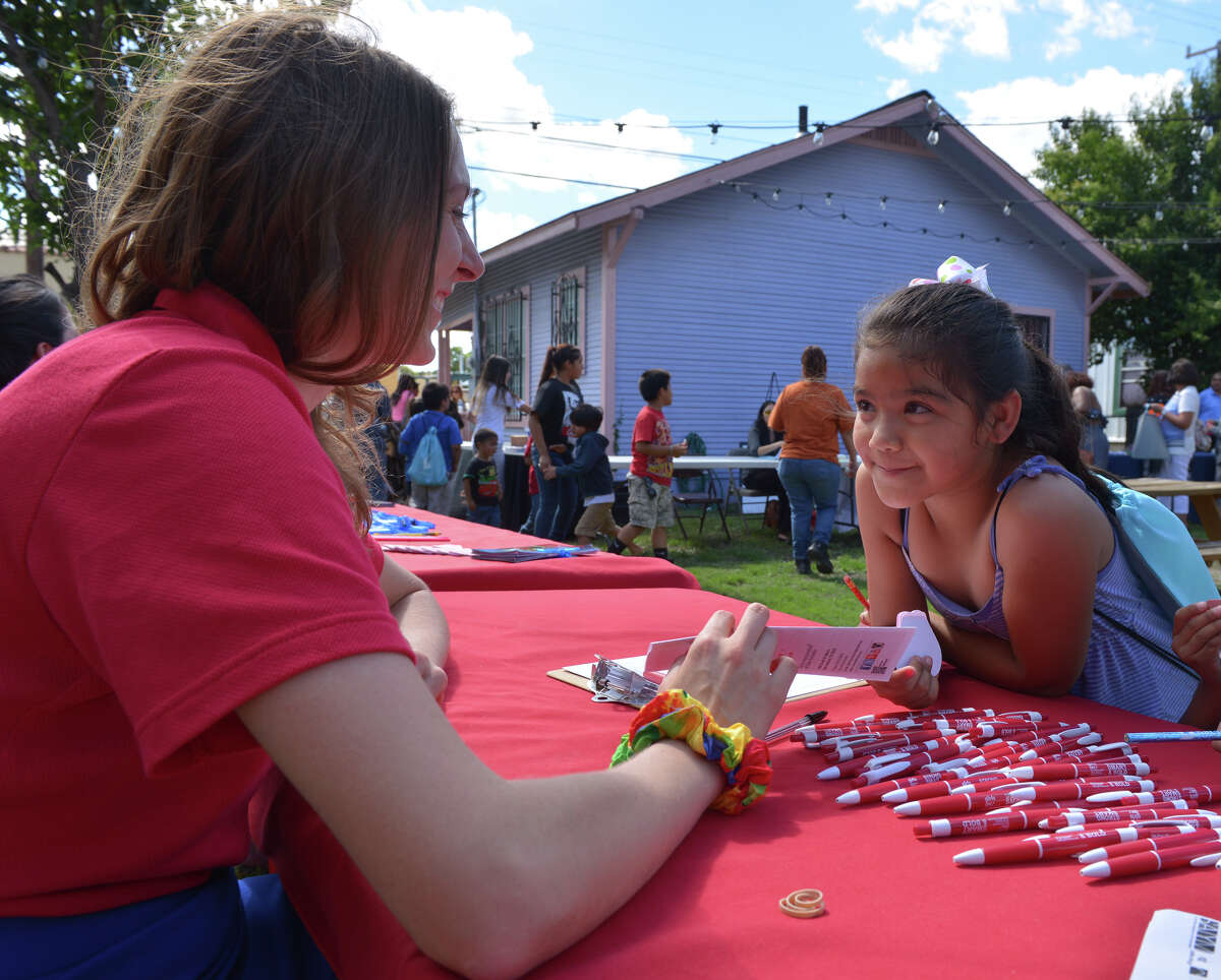 Angel Barquin, 7, talks with Sarah Amthor of Girls Inc. during the Teach for America Summertime Fair at the Guadalupe Cultural Center.