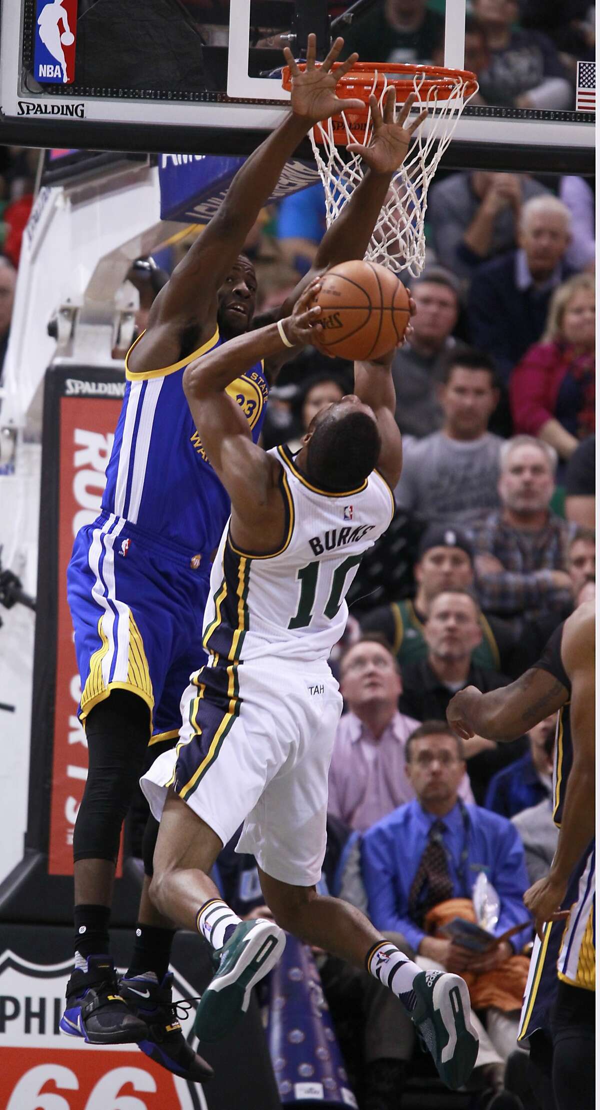 Guard Alec Burks #10 of the Utah Jazz tries to shoot over forward Draymond Green #23 of the Golden State Warriors during the first half of an NBA game November 30, 2014 at Vivint Smart Home Arena in Salt Lake City, Utah.